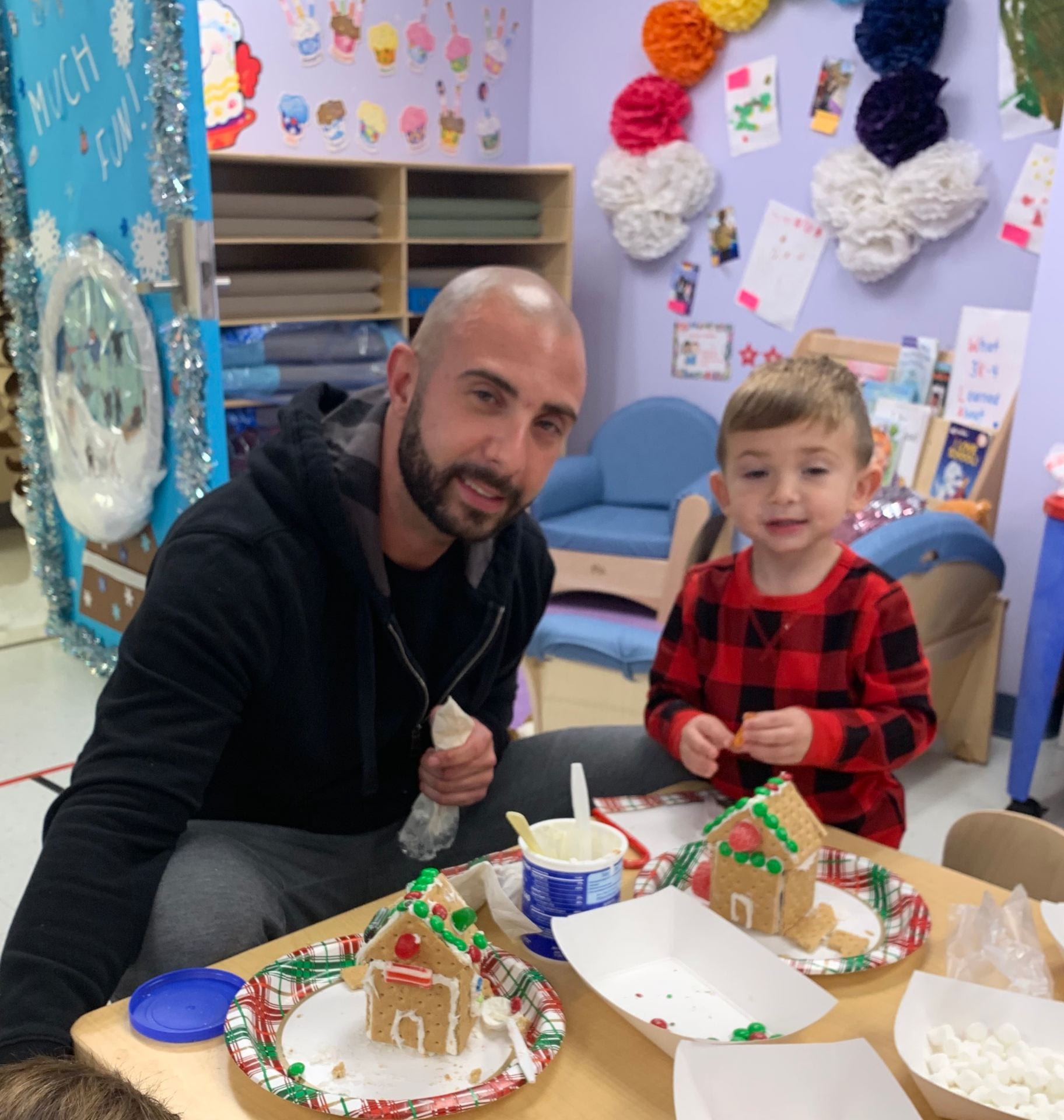 Student and his dad are creating a beautiful gingerbread house.