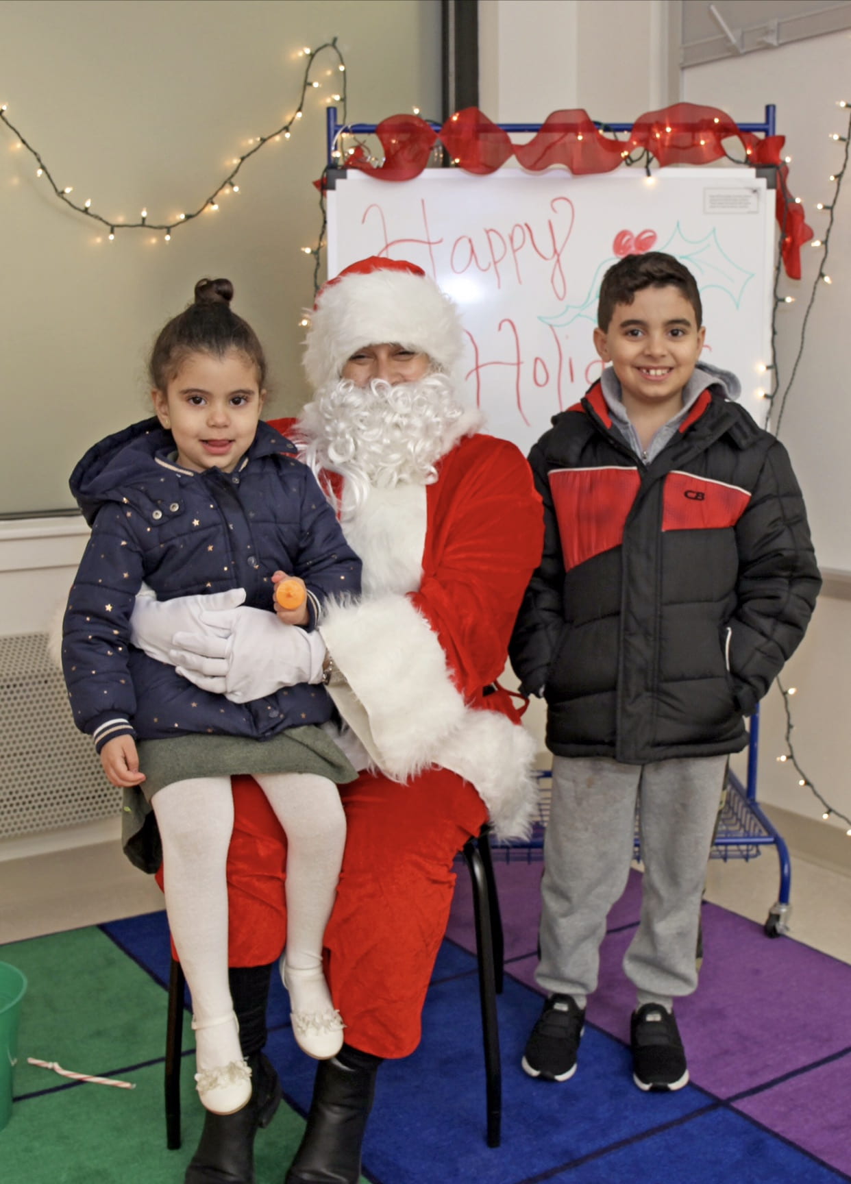Students taking pictures with Santa Claus at the holiday fair.