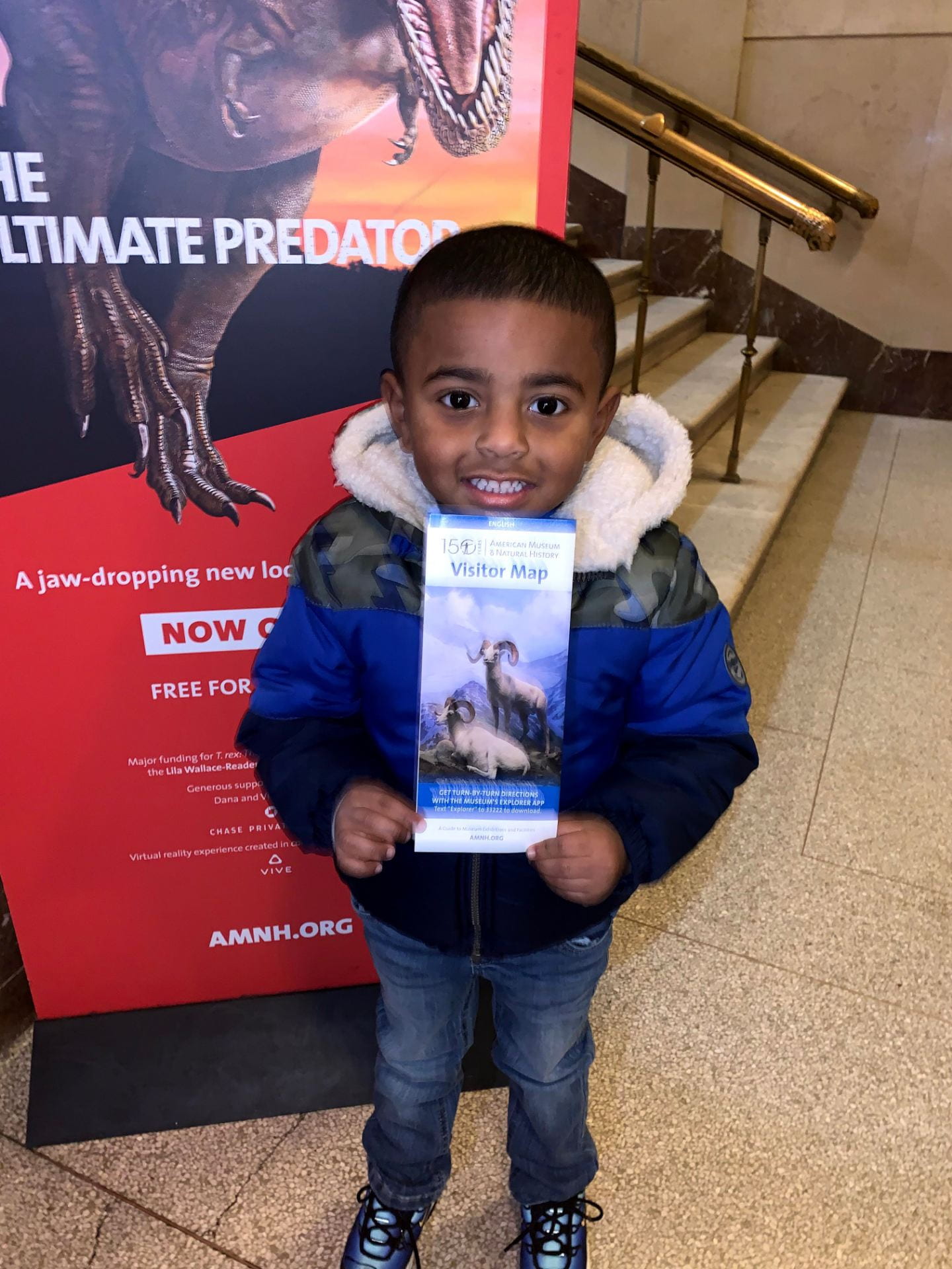 child holing up a brochure for the american museum of natural history
