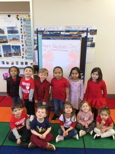class posing by a happy valentines day sign
