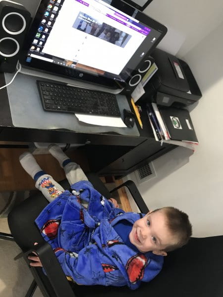 child is sitting at a computer ready for remote learning