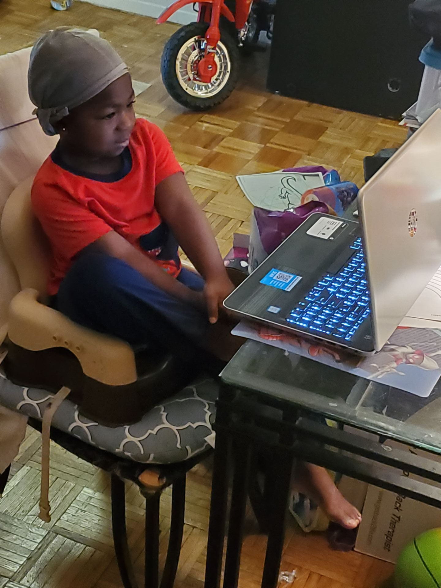 child sitting on a chair looking at a laptop
