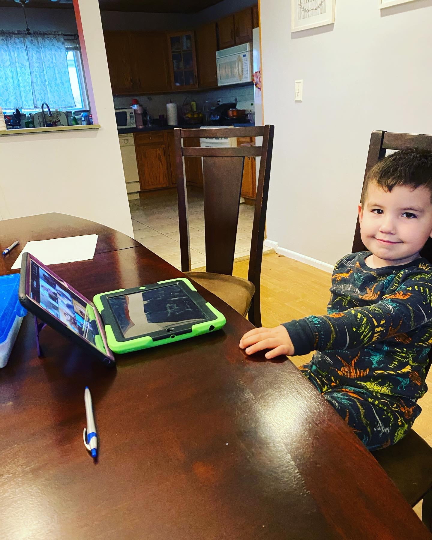 child sitting at a dining room table during remote learning