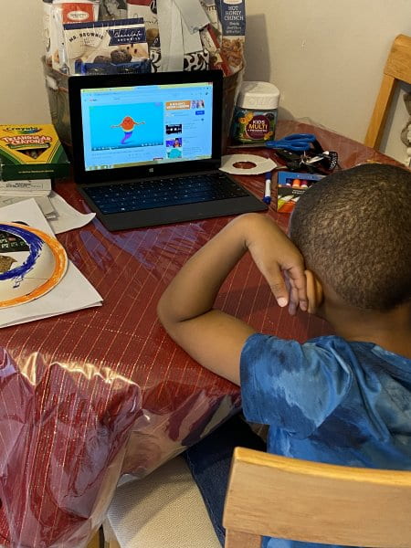 child doing remote learning on laptop