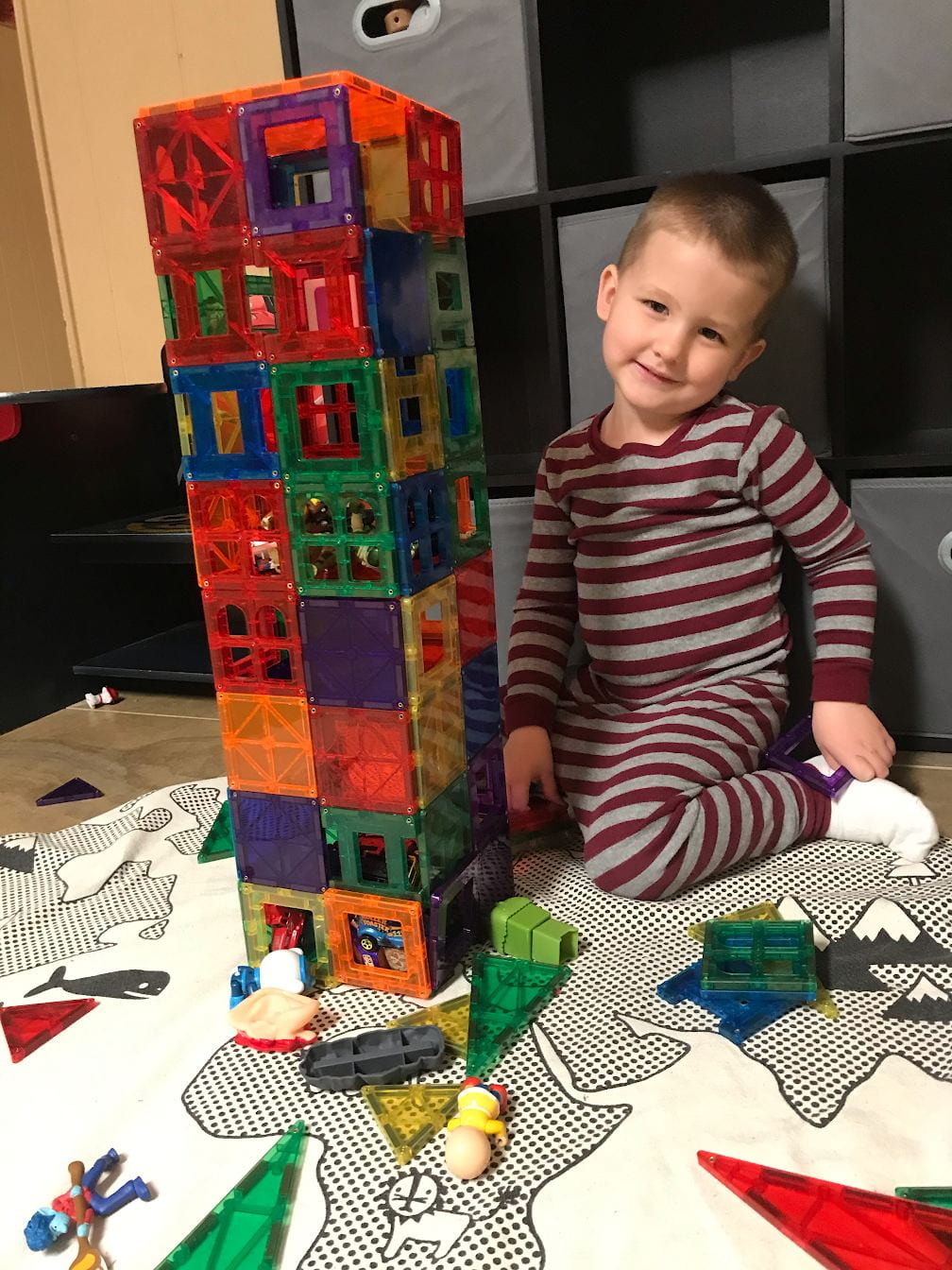 child building a tower with magna tiles