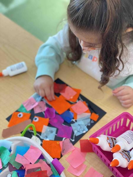 child making an art project with tissue paper